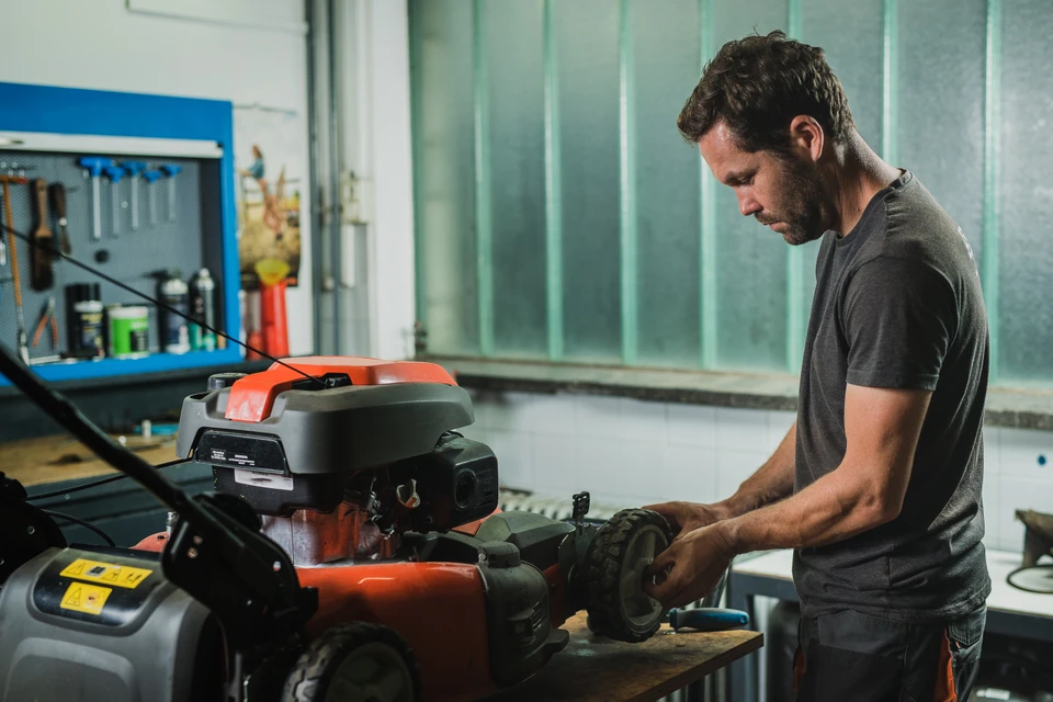 Un motard mâle fort répare sa moto dans le garage