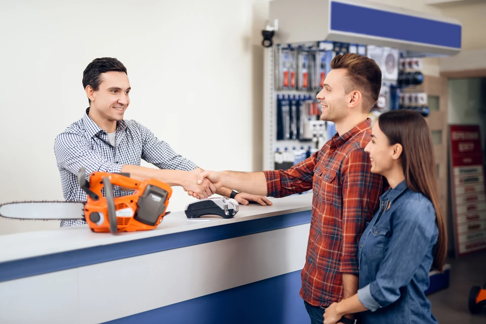 un client examine de nouveaux modèles de tondeuses à gazon dans un magasin d'électricité pour les jardiniers et les horticulteurs